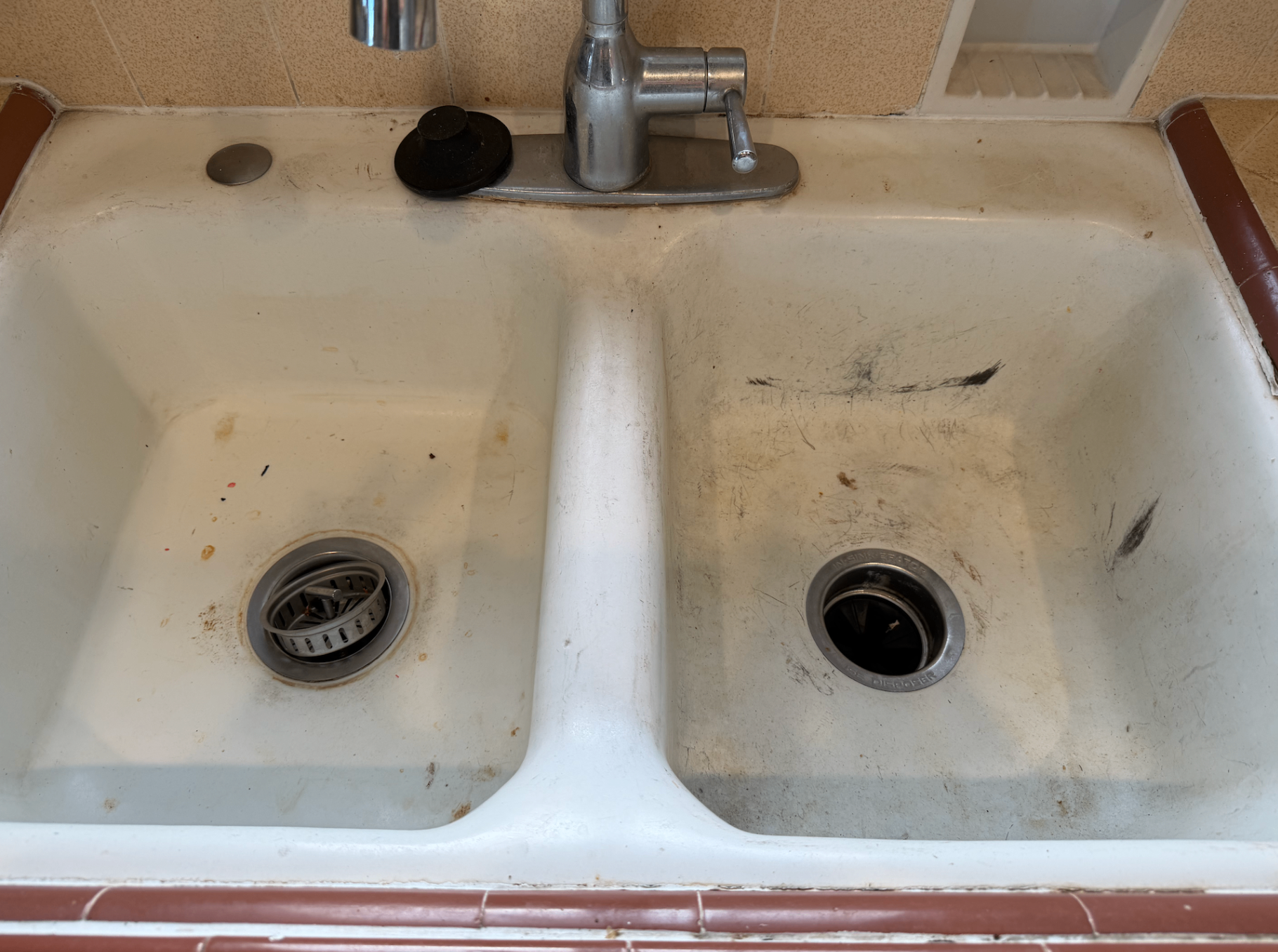 Double kitchen sink before cleaning with dark scuffs, residue, and grime.